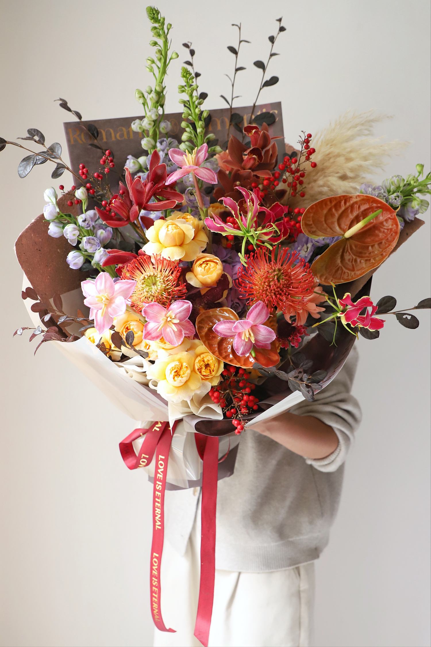 紅掌、針墊花、蘭花與玫瑰紅橙大型花束